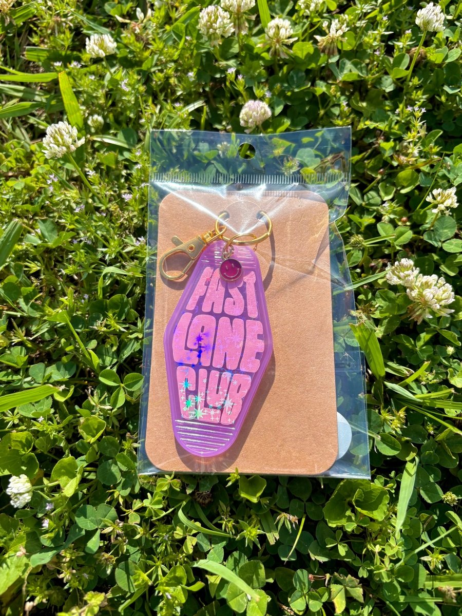 handmade motel style purple holographic acrylic keychain bold pink lettering fast lane club sparkle details gold clasp purple smiley charm