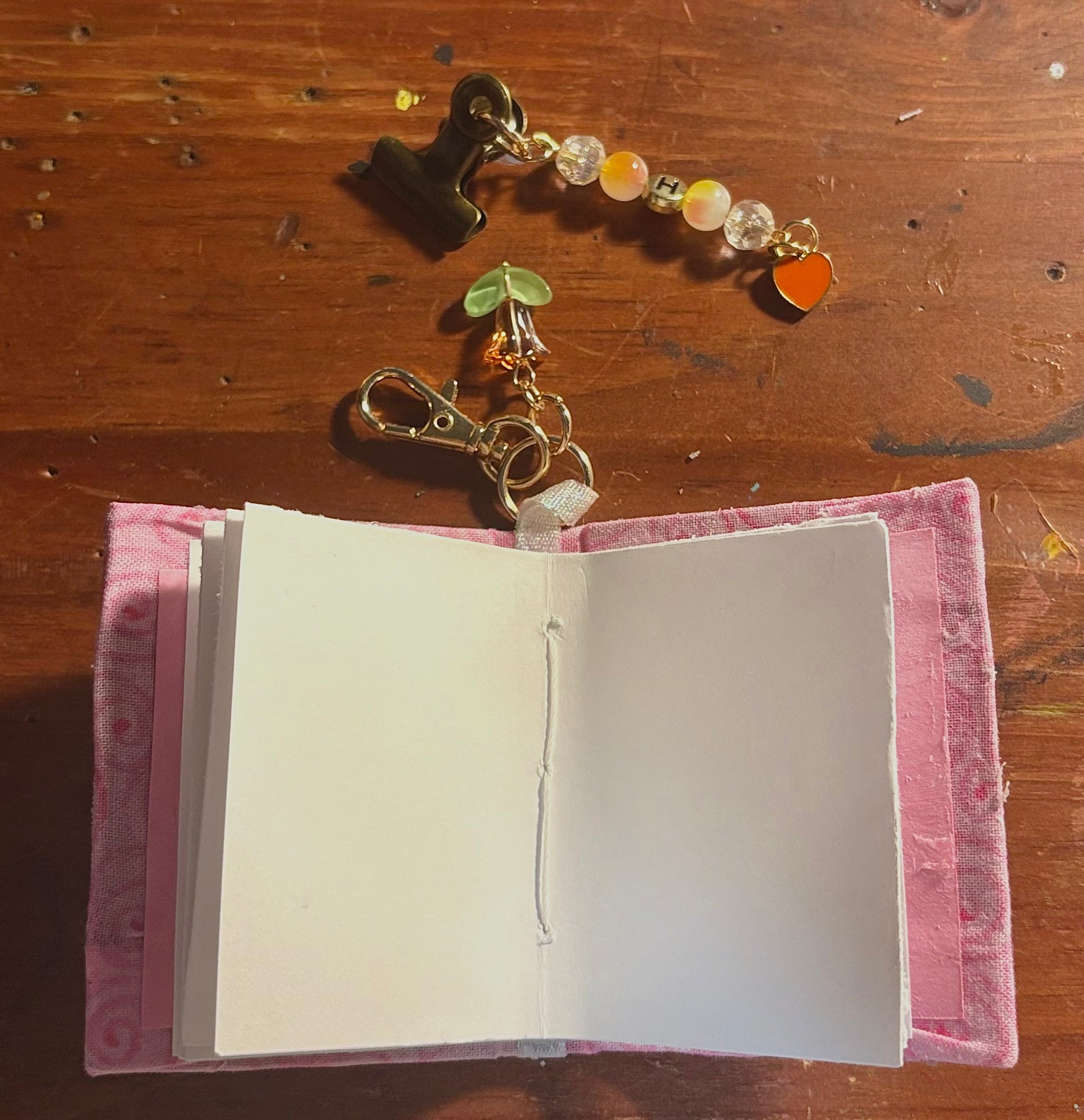 custom pocket journal open flat showing soft deckle-edge pages and pink fabric cover, handmade by happy doodle studio