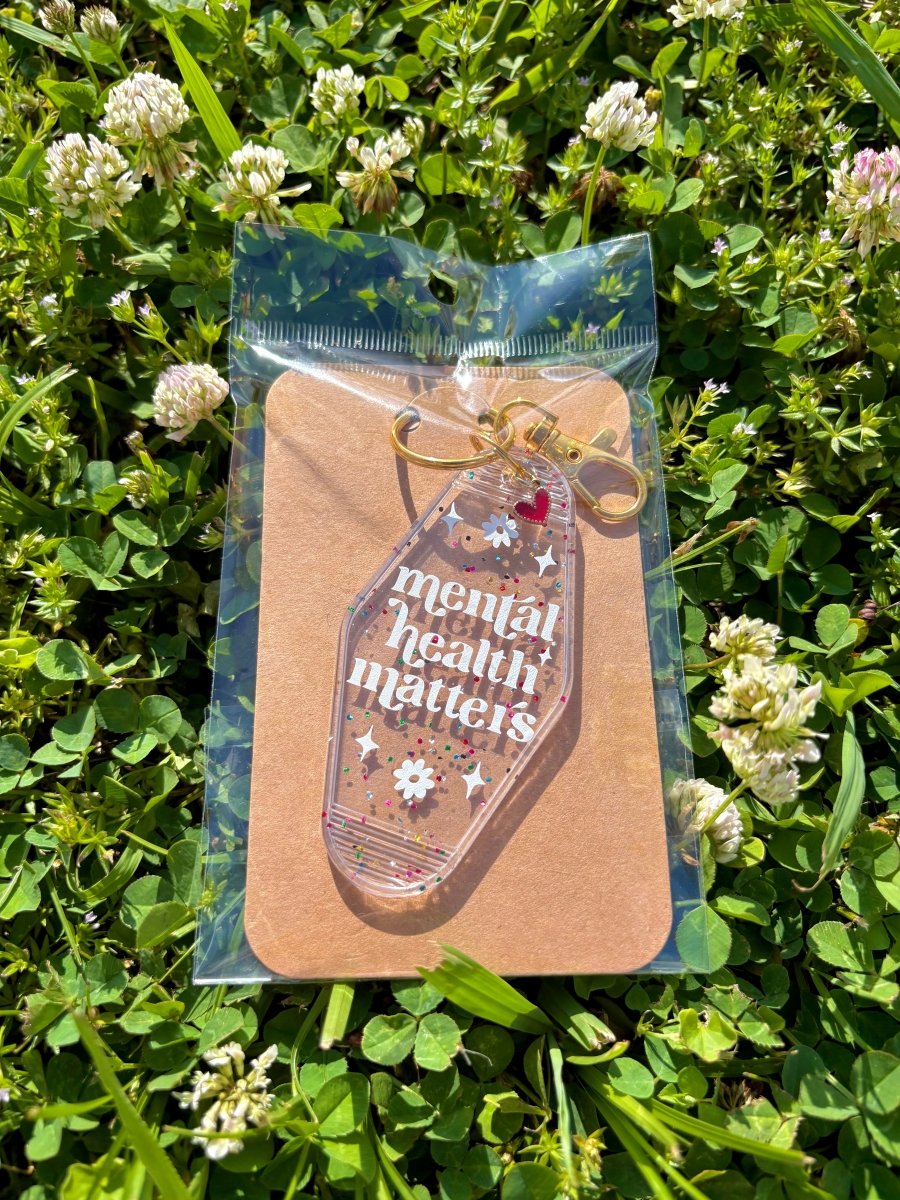 handmade motel style clear glitter acrylic keychain white lettering mental health matters daisy details gold clasp red heart charm